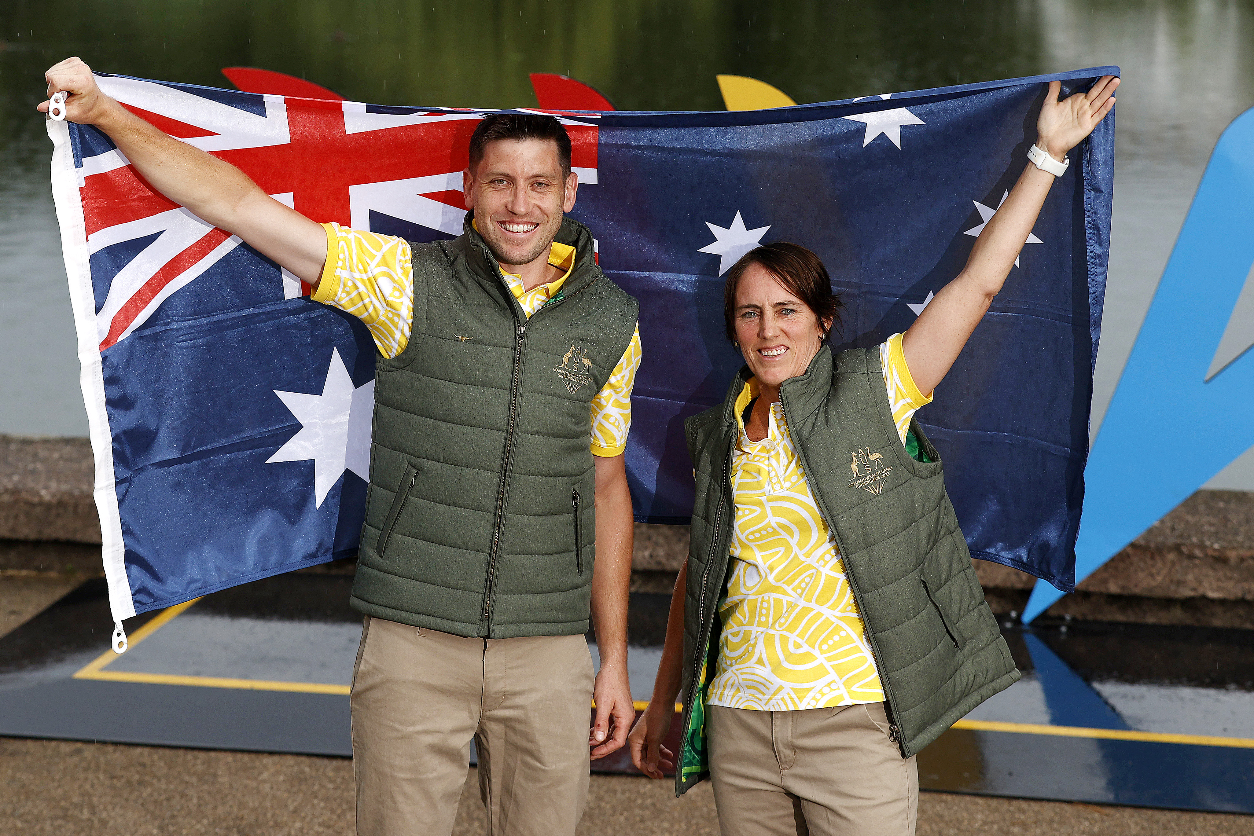 Squash player Rachael Grinham and Kookaburras co-captain Eddie Ockenden hold up the Australian fkag