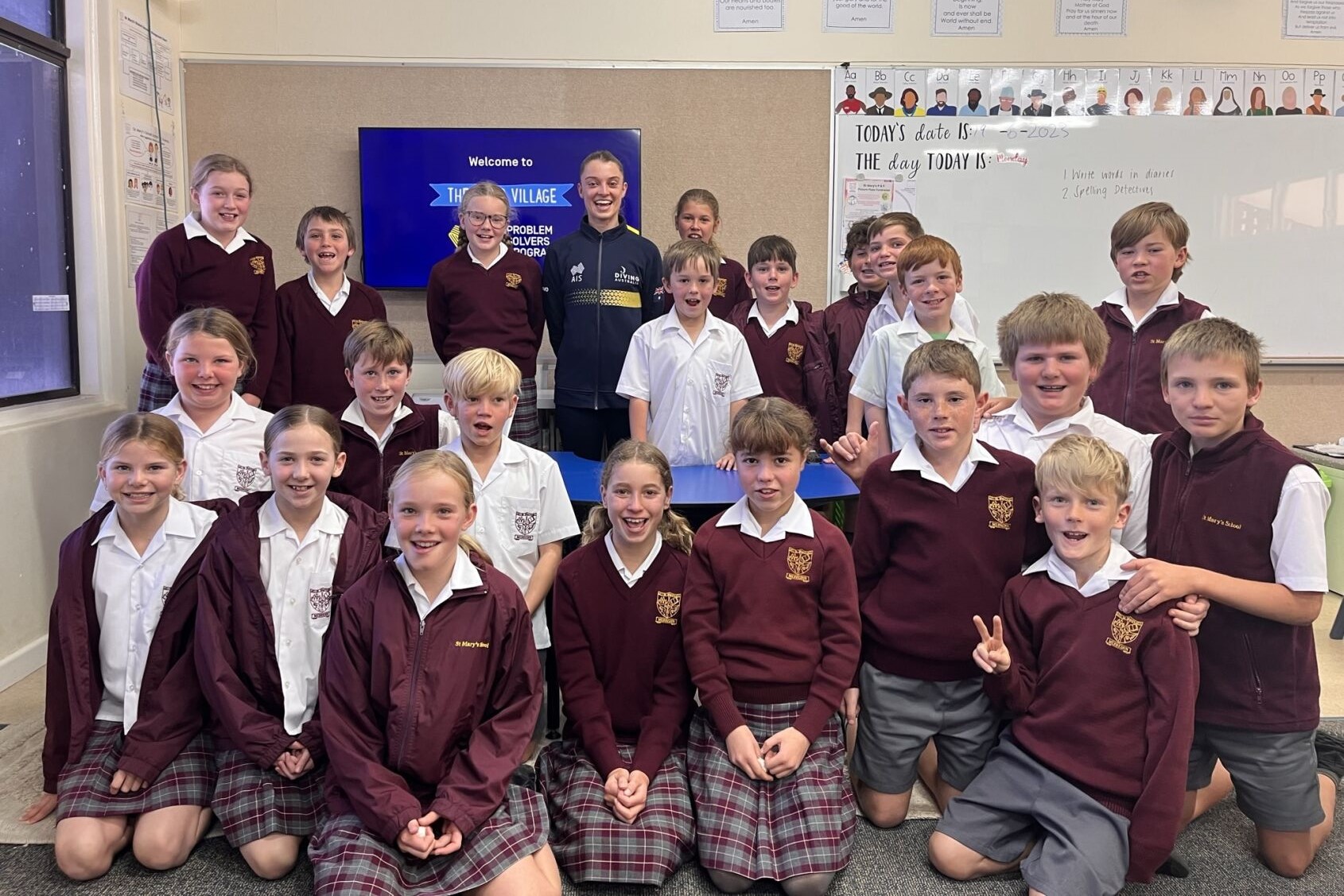 Athlete ambassador posing with a class of primary school children.