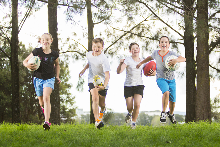 Children running in a park with balls