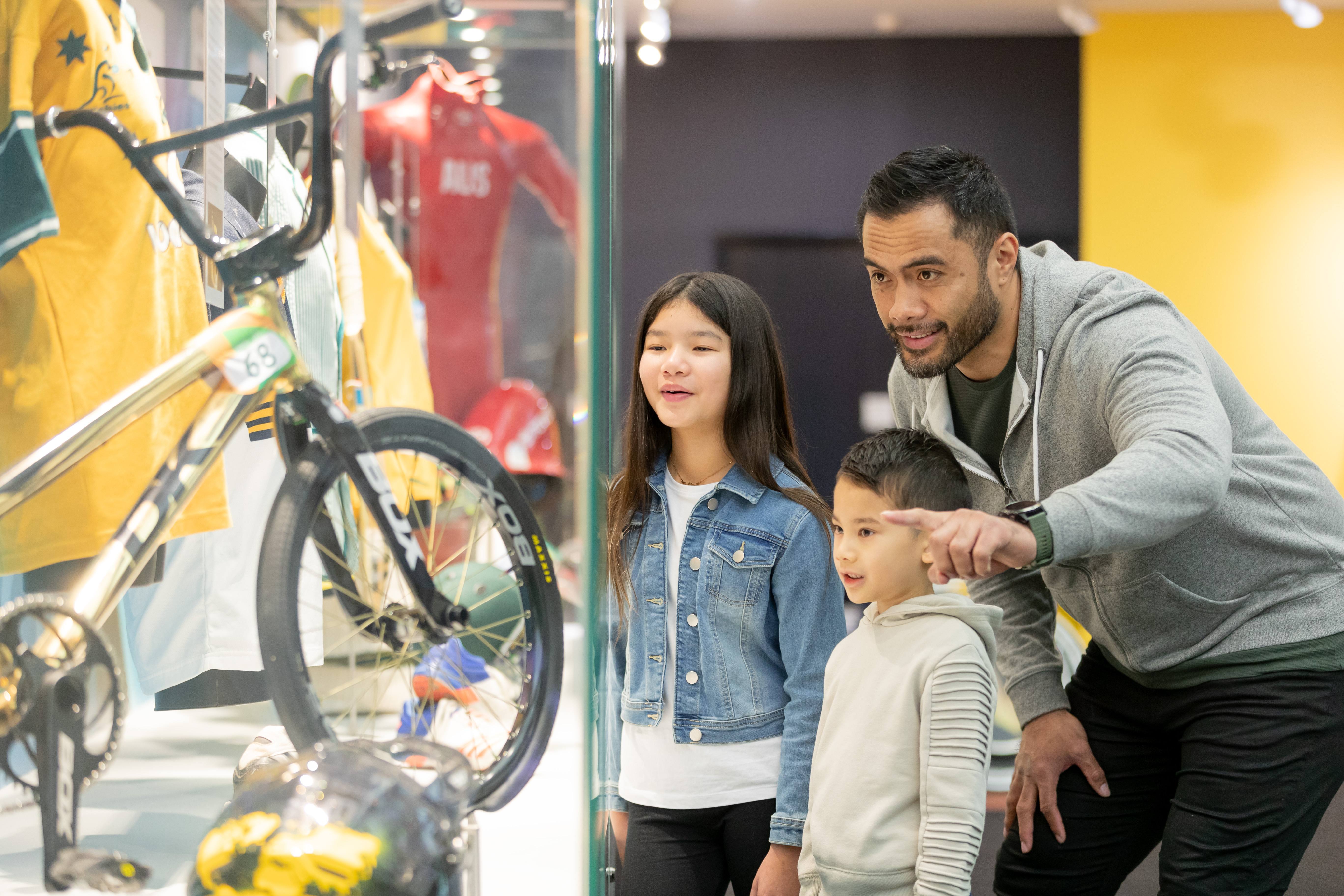 Children and dad look at Australian Sport Memorabilia in Sportex.