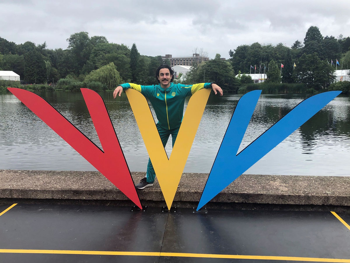 Nathan Johnson poses in front of the Birmingham sign at the main athlete village. 