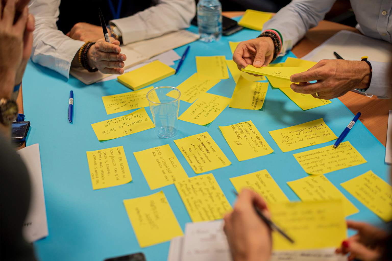 Hands stretched out over a table covered with yellow notes