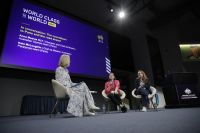 Three women sitting together on stage.