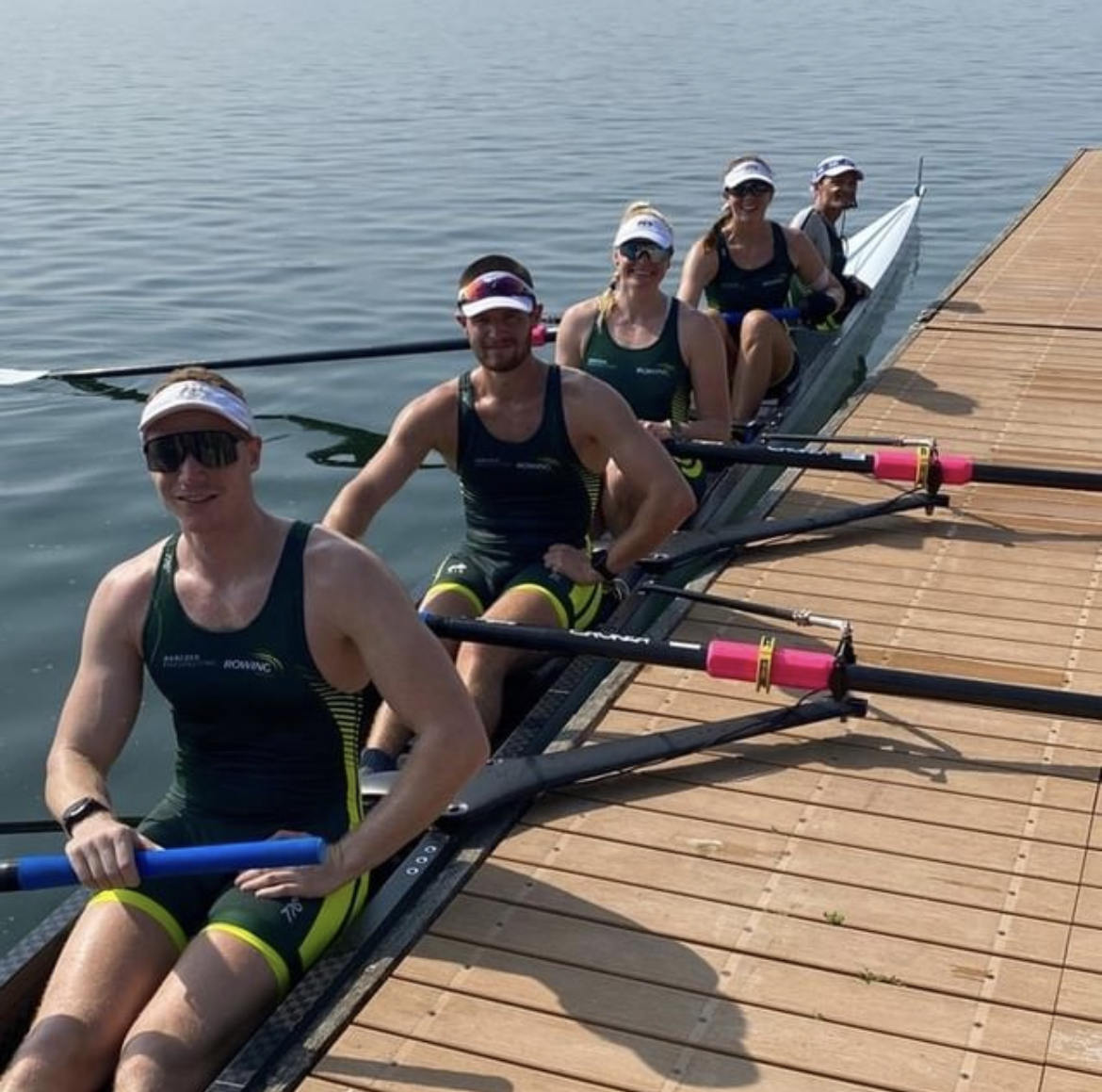 Athletes sitting in their boat on the water 