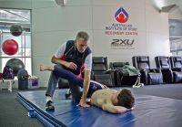 Athlete and coach stretch on the AIS recovery mat 2012