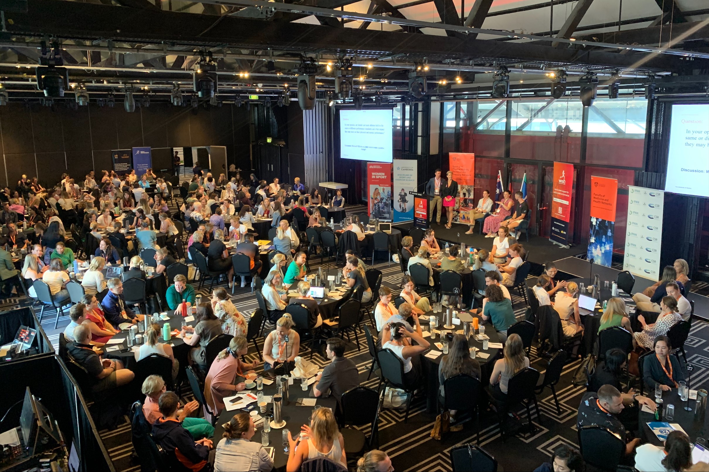 Room of people sitting at tables.