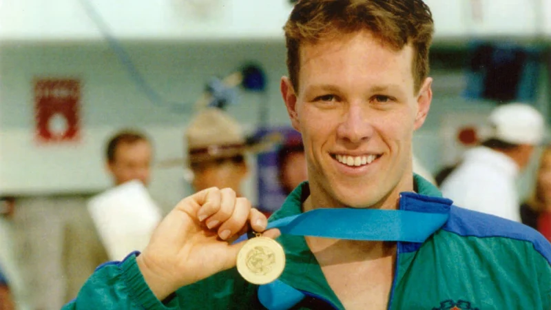 Kieren Perkins holds up his Four-time Commonwealth Games medals