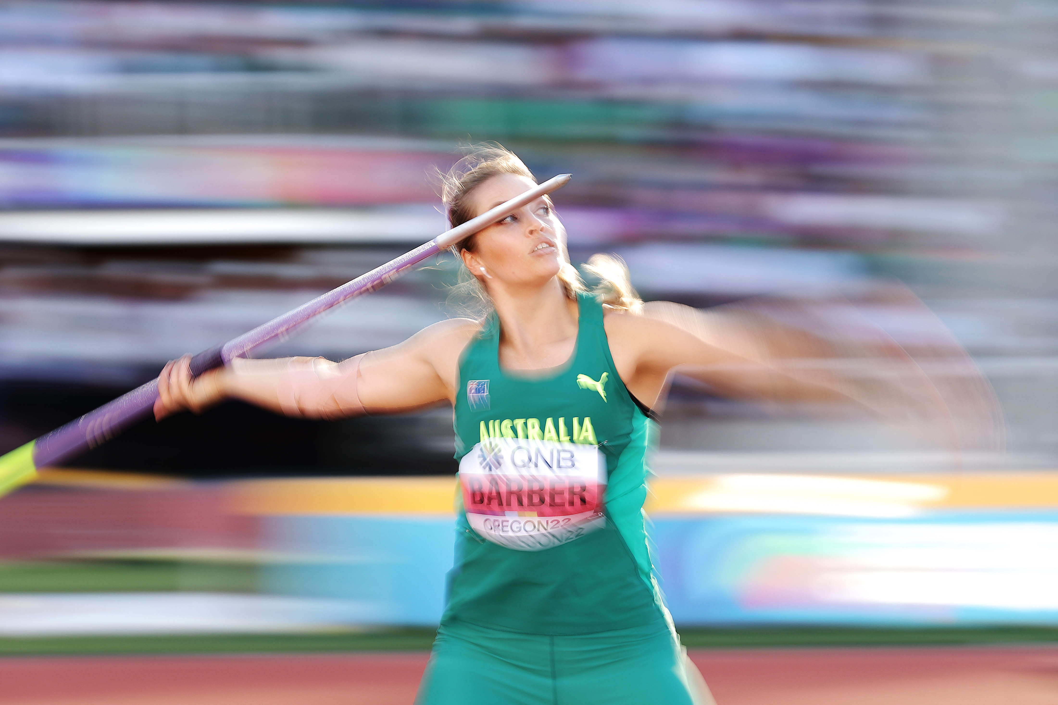 Kelsey Lee Barber about to throw javelin with background blurred.